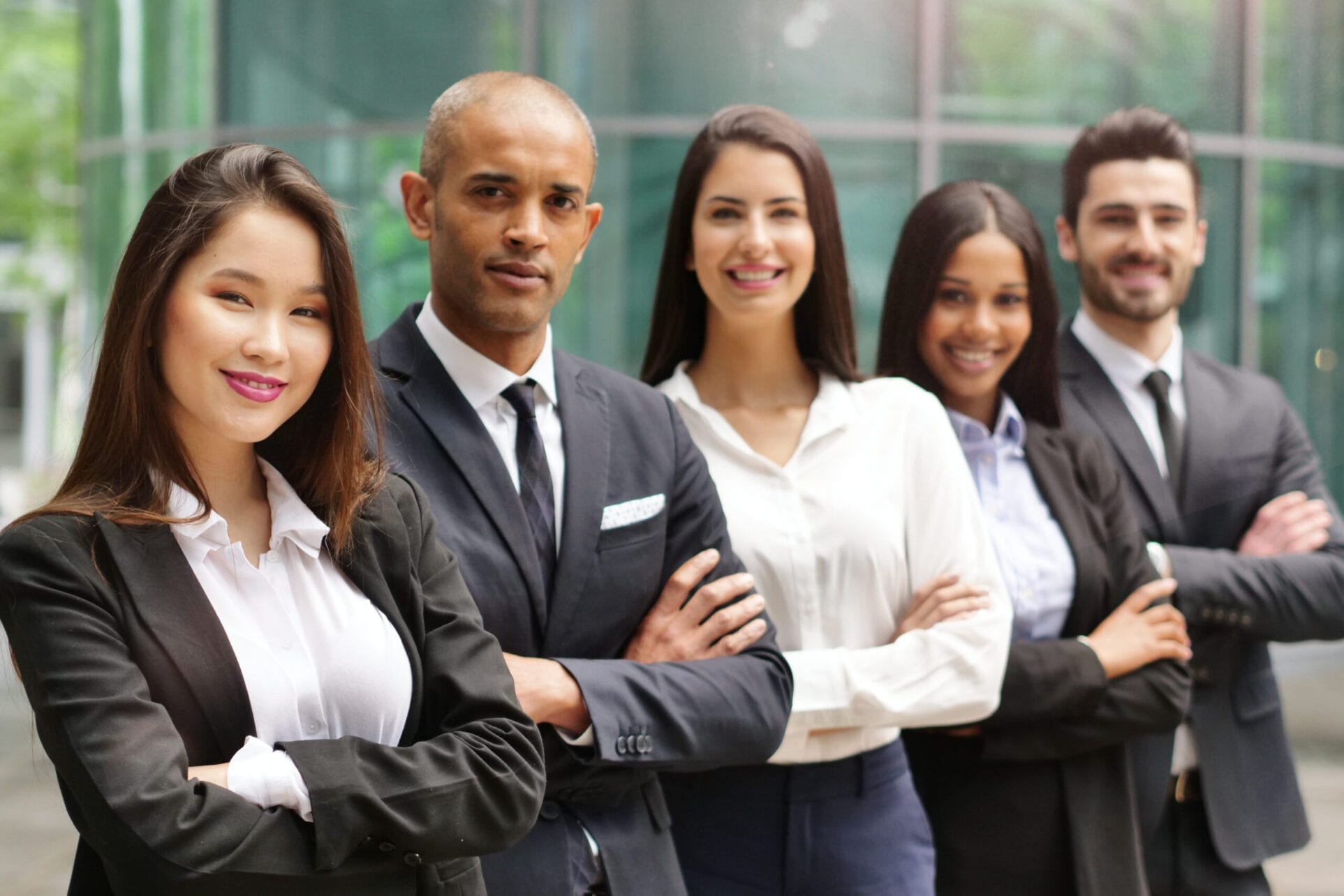 Portrait of business people of different ethnic backgrounds dressed in suits, they smile and cross their arms. Concept of: internationality and career, cooperation and team.